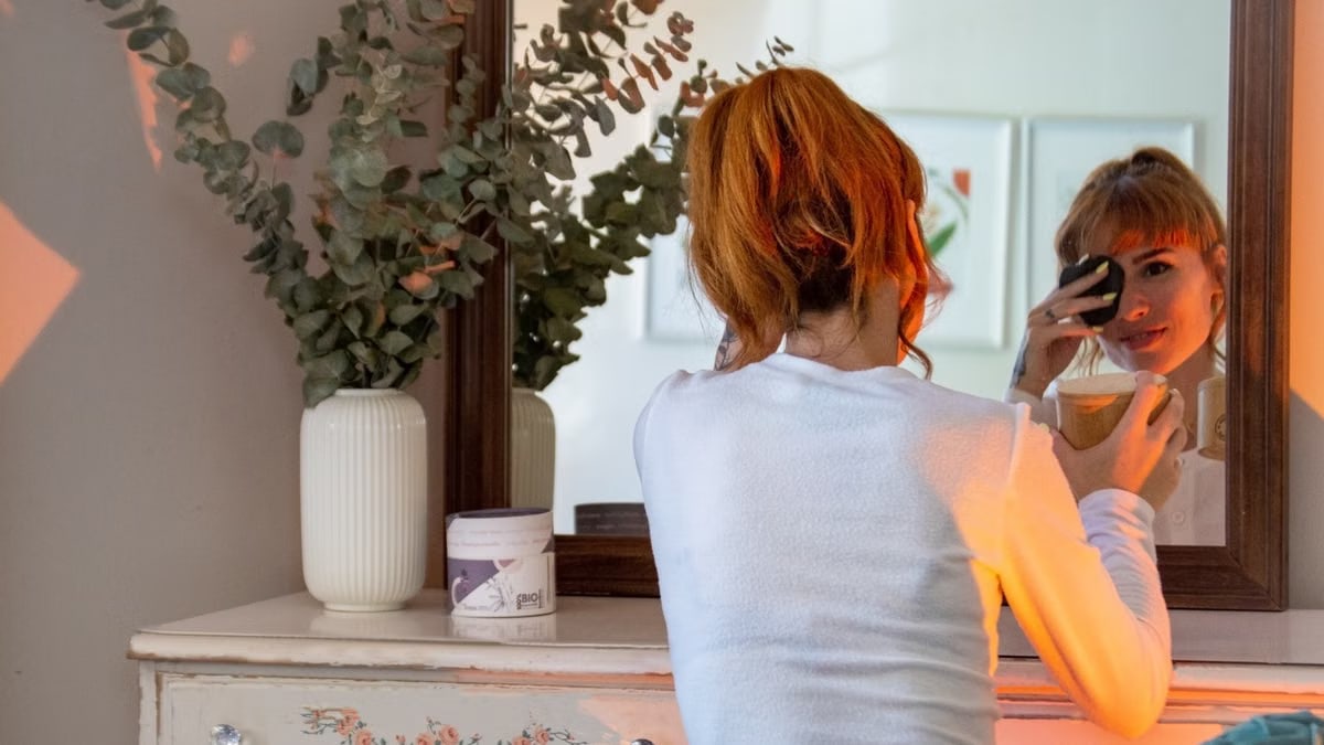 Woman enjoys a cozy morning routine with makeup and coffee in a stylish Montréal apartment.